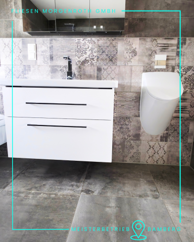 Moderne Badezimmer mit weißem Unterschrank, Waschbecken und stilvollem WC.